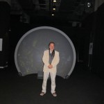 Rainer Maria Latzke in front of a parabolic projector screen